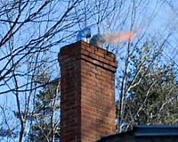 Chimney fire seen coming out the top of the chimney.